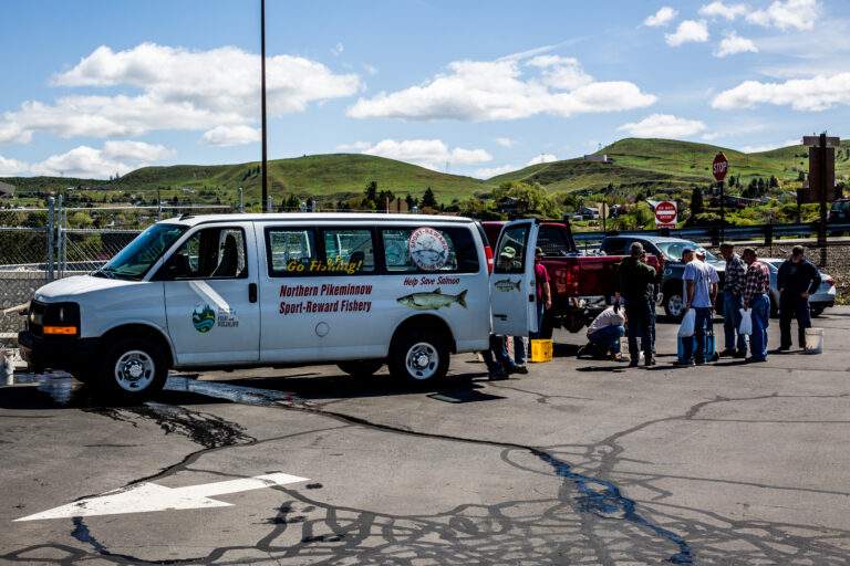 People standing in line to turn in Pikeminnow at a program van